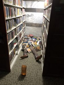 fake legs sticking out from a pile of books
