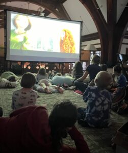 Children watching movie on big screen at NWPL