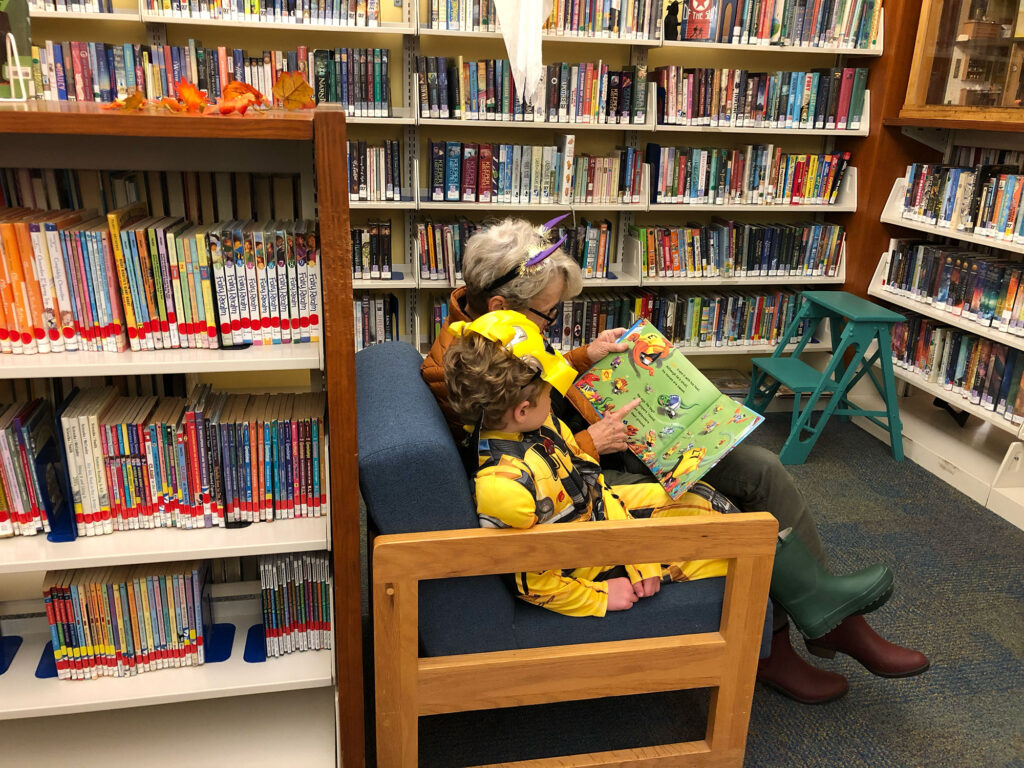 Adult and child reading a Haloween story