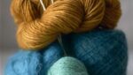 Blue and gold yarns with knitting needles