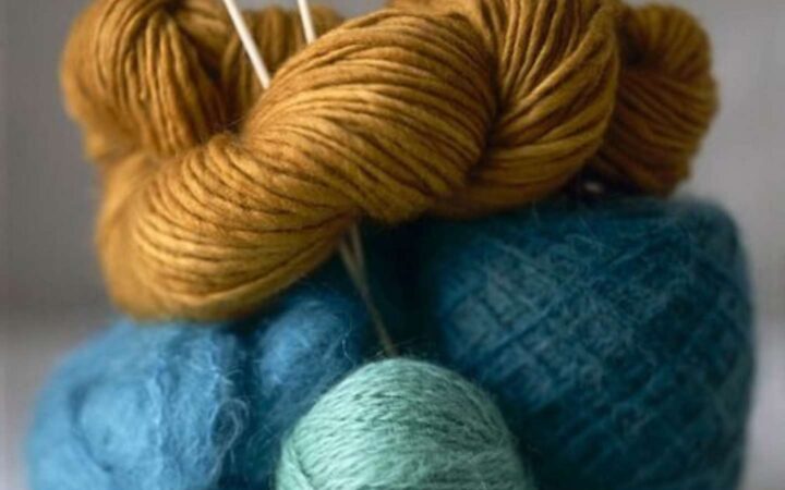Blue and gold yarns with knitting needles