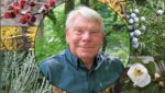Warren Leach with photos of plants from the cover of his book