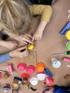 child decorating a potato with colored clay