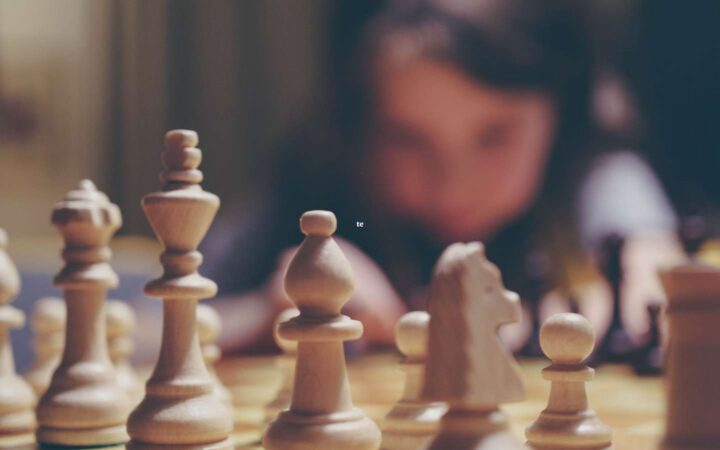 chess pieces with a child in the background